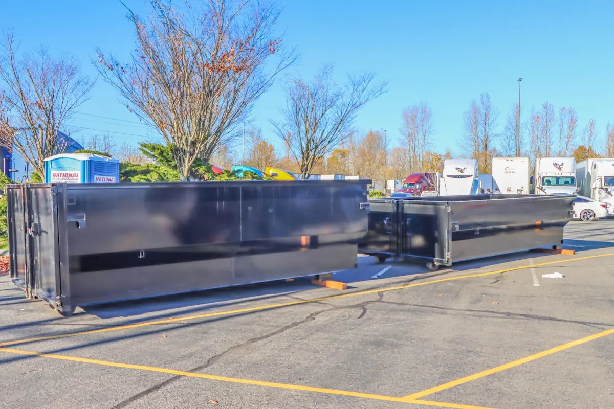 Professional dumpster rental service with roll-off container on residential driveway in Ontwa